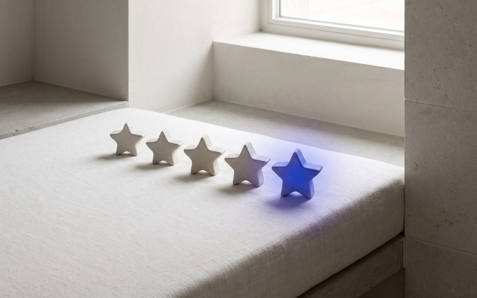 Five small ceramic stars in a row, the last one glowing blue