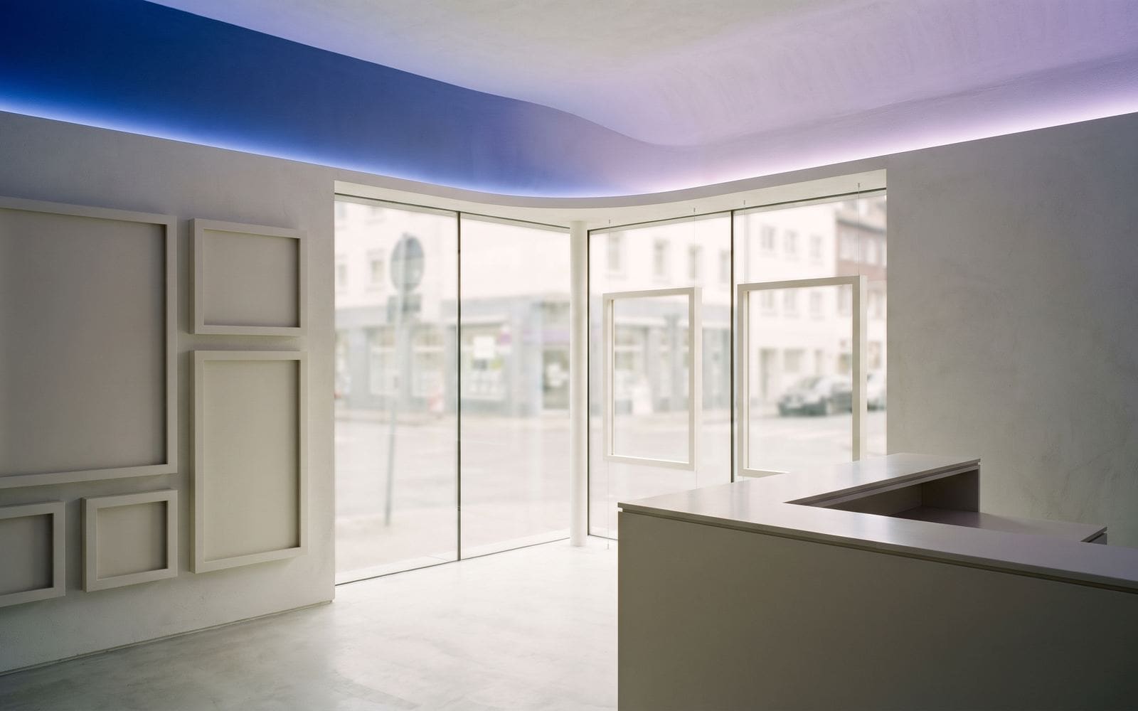 The interior of a modern real-estate storefront with a glass front and a reception desk